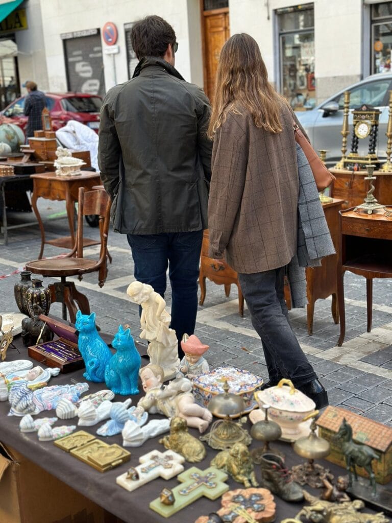 Personas recorriendo los puestos de antigüedades de El Rastro de Madrid