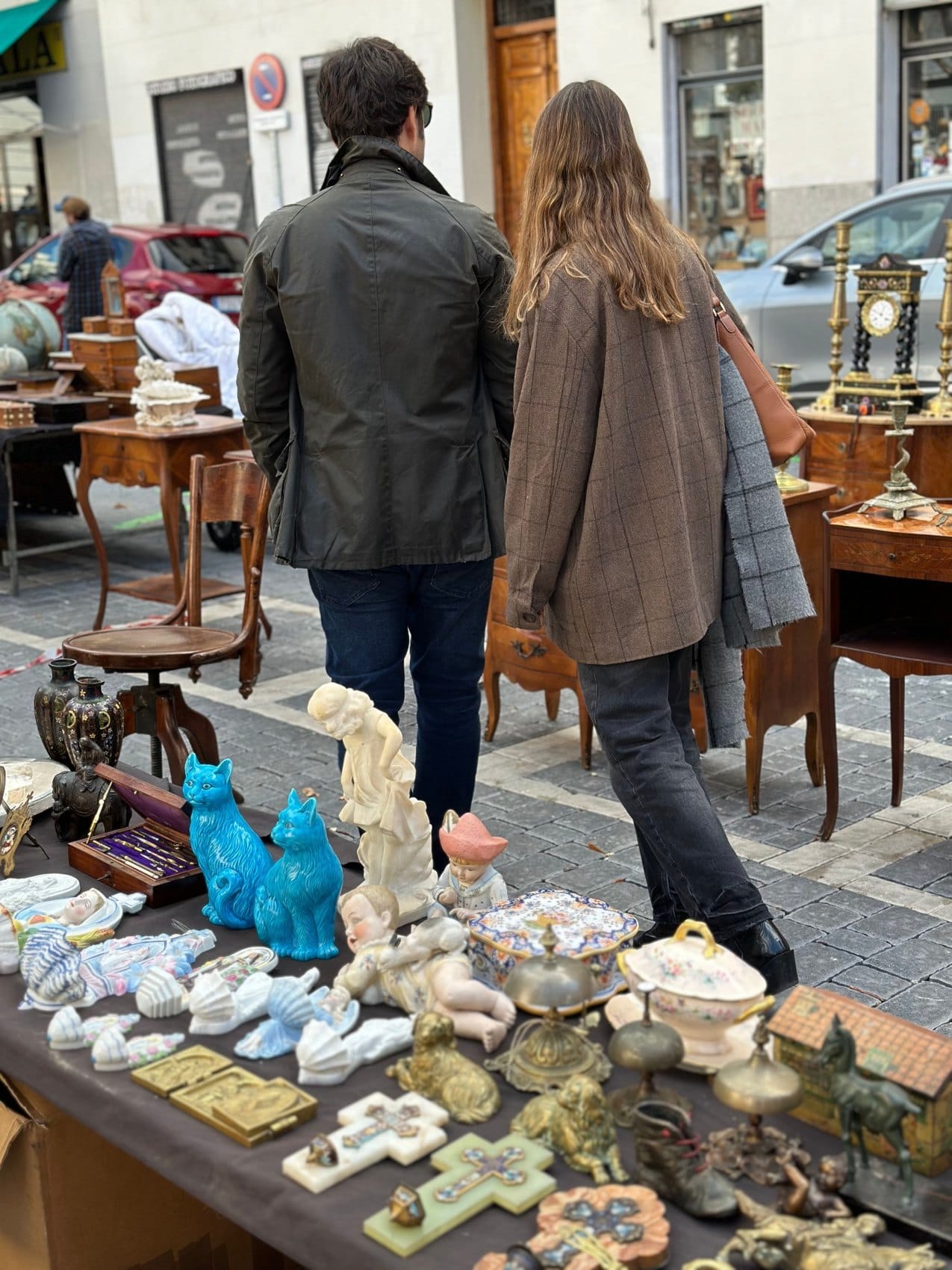 Personas recorriendo los puestos de antigüedades de El Rastro de Madrid